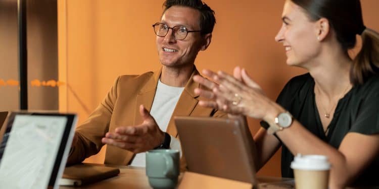 Frases que prejudicam a carreira: profissionais conversando em reunião de trabalho com comunicação assertiva