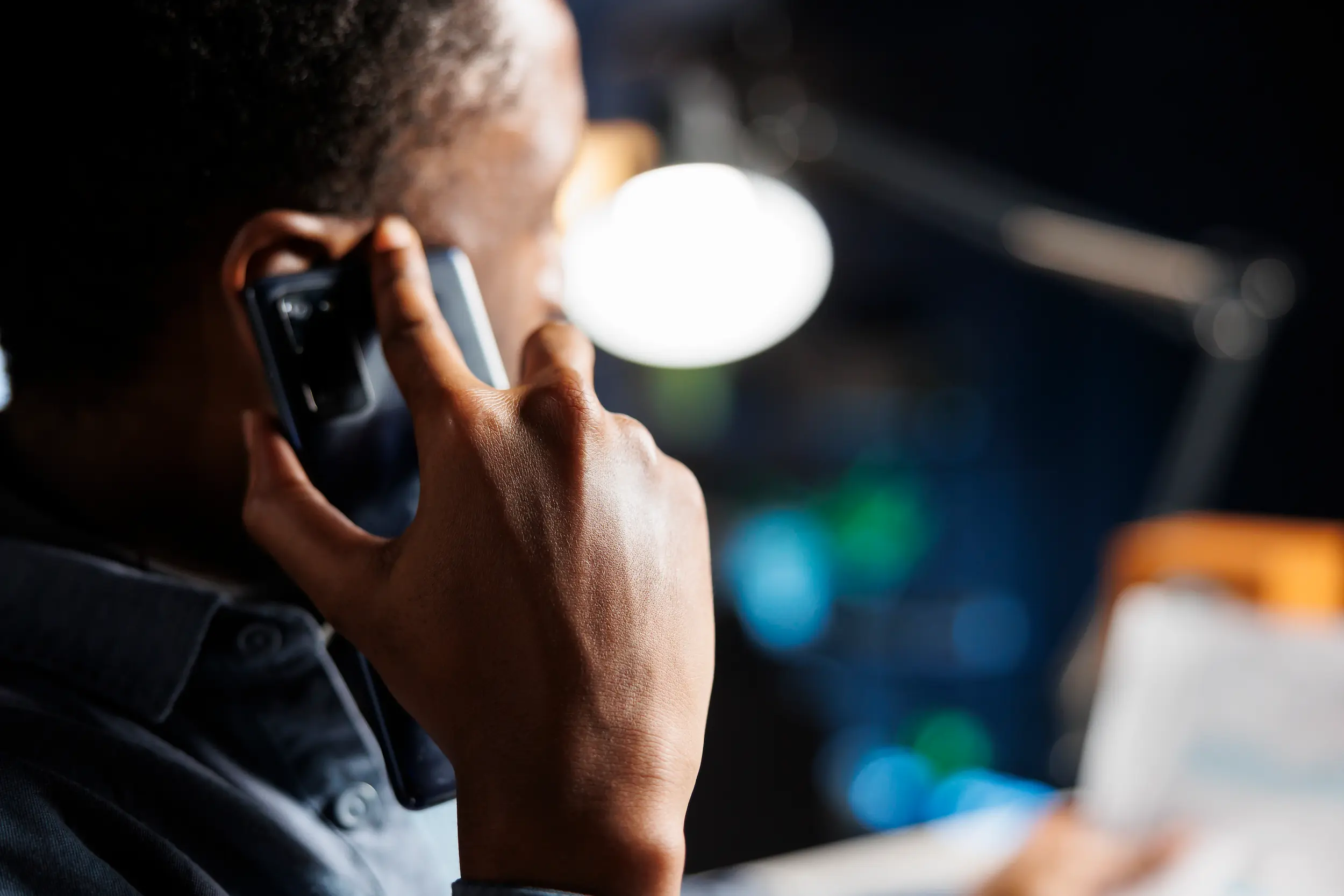 Homem atendendo ligação no celular enquanto criminosos aplicam golpe se passando pelo banco do cliente.