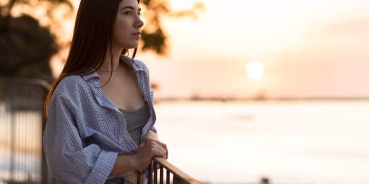 Hábito de reconhecer emoções — mulher jovem em momento de reflexão ao pôr do sol