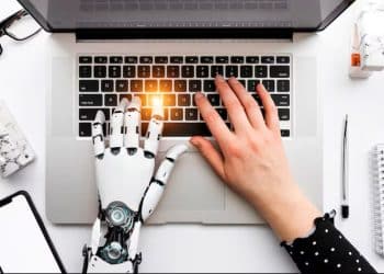 Profissional trabalhando com Inteligência Artificial em computador analisando dados no ambiente de trabalho.