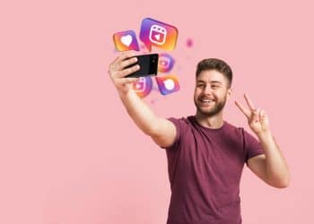 Homem tirando selfie com smartphone enquanto ícones de redes sociais representam novos recursos premium do Instagram como visualização anônima de stories.