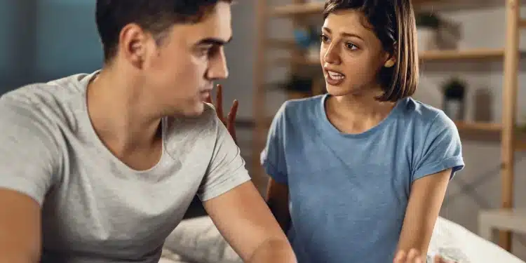 Mulher expressando sentimentos enquanto homem escuta em conversa séria na sala de casa