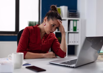 Mulher trabalhando no escritório representando desigualdade de oportunidades no mercado de trabalho.
