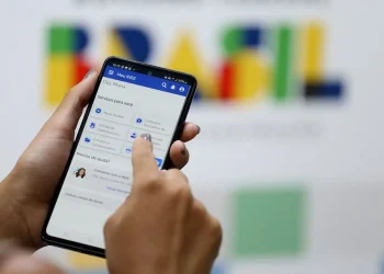 Segurado acessa aplicativo Meu INSS no celular para verificar descontos no benefício previdenciário.