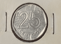 Visão detalhada do reverso de uma moeda de 25 centavos de 1994, mostrando o numeral 25 sobre as listras diagonais e a palavra "CENTAVOS" na base, em um suporte de proteção para colecionadores.