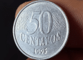Close do reverso de uma moeda de 50 centavos de 1995, destacando o ano de cunhagem e o estado de conservação da peça.