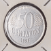 Close-up de uma moeda de 50 centavos de 1995 da primeira família do Real, protegida em um suporte para colecionador (coin holder).