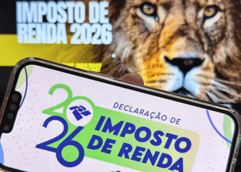 Celular com app da declaração do Imposto de Renda 2026 e leão da Receita Federal ao fundo