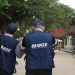 Dois agentes do IBGE de costas caminhando em área urbana durante trabalho de campo
