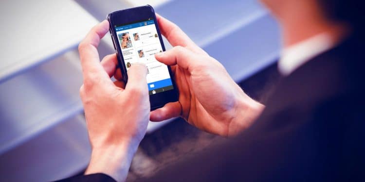 Pessoa navegando em um aplicativo de redes sociais no smartphone, ilustrando a interação digital.