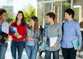 Grupo de estudantes universitários caminhando e conversando em um campus, representando oportunidades de estágio para alunos de Direito e Economia.