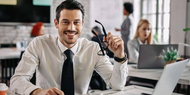 Profissional sorridente de terno em escritório moderno — destaques entre as profissões mais bem remuneradas com salários de até R$ 50 mil por mês