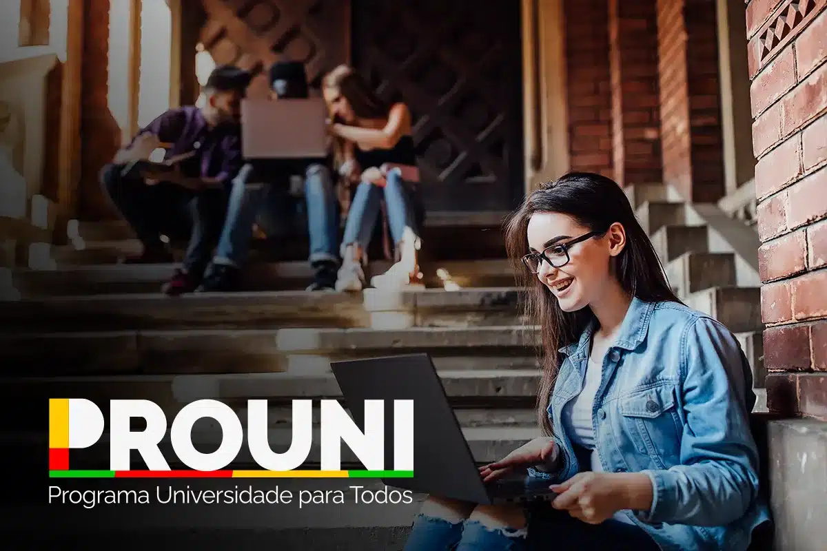Estudante consultando informações sobre o Prouni em um laptop, com outros colegas ao fundo.