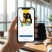 Mão segura celular mostrando tela inicial do app gov.br em escritório iluminado