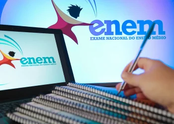 Estudante revisando estratégias para tirar nota 1000 na redação do Enem com materiais de estudo e computador aberto.