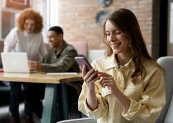 Profissionais trabalhando em ambiente colaborativo, usando redes sociais para crescer na carreira.