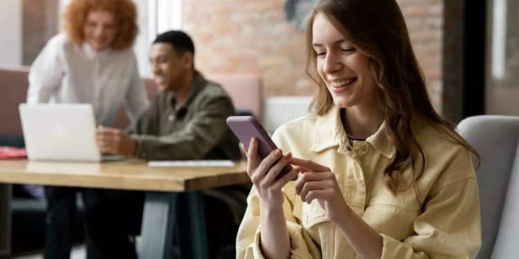 Profissionais trabalhando em ambiente colaborativo, usando redes sociais para crescer na carreira.