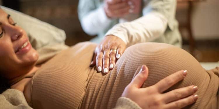 Doula realizando técnica de conforto em gestante durante acompanhamento humanizado no período pré-parto.