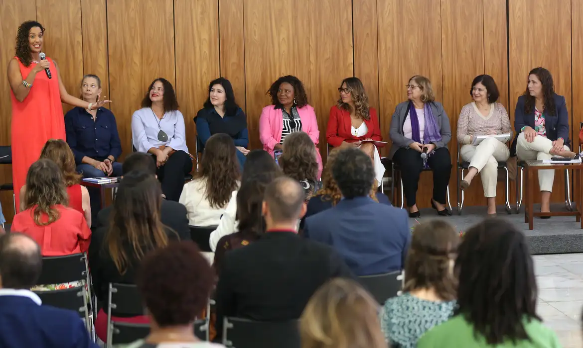 Grupo diverso de mulheres reunidas em evento de debate, simbolizando a união feminina como resposta ao rótulo da rivalidade que a sociedade insiste em manter