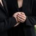 Duas pessoas vestidas de preto segurando as mãos em momento de luto e apoio emocional.