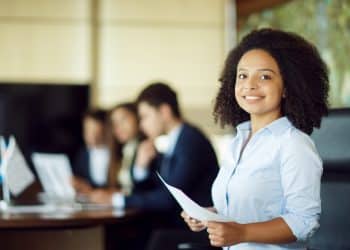 Jovem estudante negra sorrindo com documento — Programa Partiu Estágio abre 5.874 vagas na Bahia em 2025