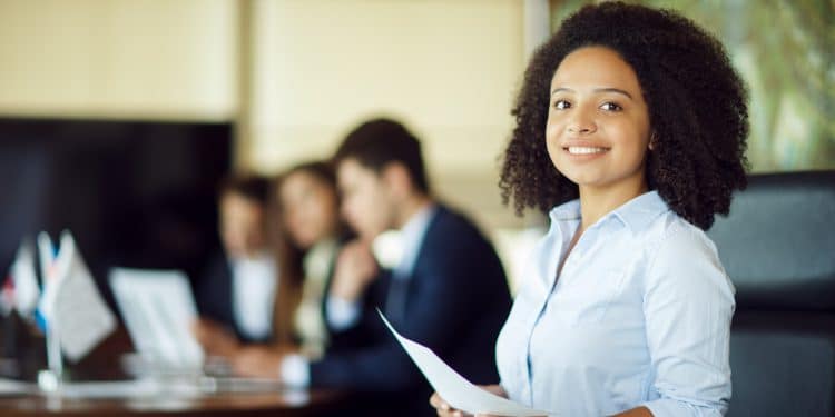 Jovem estudante negra sorrindo com documento — Programa Partiu Estágio abre 5.874 vagas na Bahia em 2025