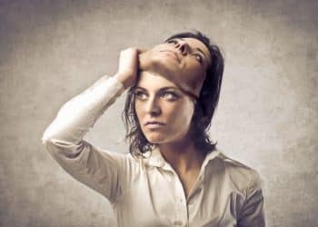 Mulher retirando máscara simbolizando manipulação emocional e falsidade escondida em atitudes aparentemente sinceras.