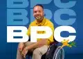 Homem sorrindo em cadeira de rodas com camiseta amarela, representando o Benefício de Prestação Continuada (BPC), com o logo do programa ao fundo.