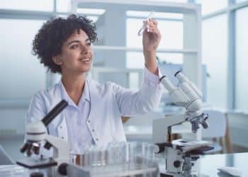 Jovem biomédica em laboratório.