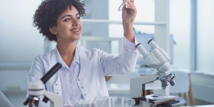 Jovem biomédica em laboratório.