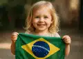 Criança feliz com bandeira do Brasil.