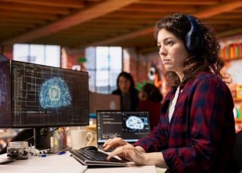 Desenvolvedora de IA analisa visualização de cérebro digital em escritório moderno.