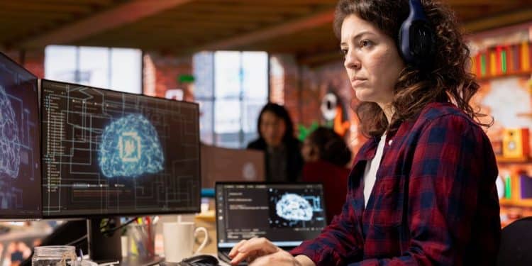 Desenvolvedora de IA analisa visualização de cérebro digital em escritório moderno.