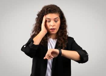 Mulher preocupada olhando para o relógio.