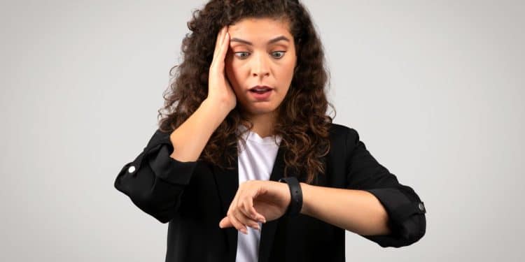Mulher preocupada olhando para o relógio.