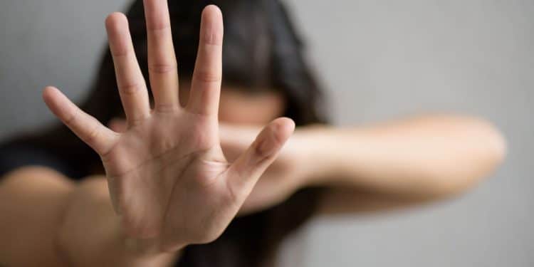 Mulher fazendo sinal de parada, representando a luta contra a violência doméstica e as novas leis sancionadas pelo presidente Lula.