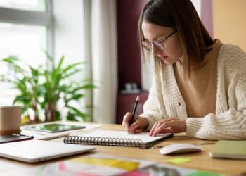 Jovem estudante faz anotações em caderno.