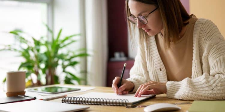 Jovem estudante faz anotações em caderno.