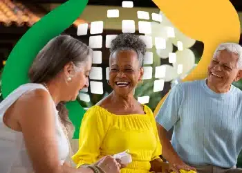 Três idosos sorrindo em confraternização ao ar livre com cores vibrantes.