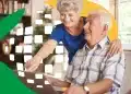 Casal de idosos sorrindo enquanto utilizam computador, representando os aposentados que serão impactados pela antecipação do 13º salário do INSS.