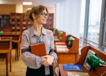 Professora em biblioteca ilustra ranking das licenciaturas com melhores salários no Brasil.