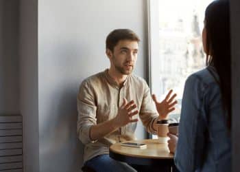 Conversa entre duas pessoas em café ilustrando reflexão sobre emoções e responsabilidade emocional.