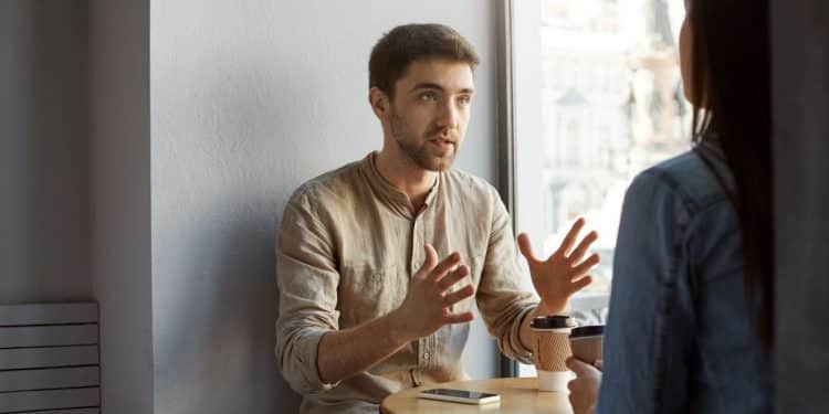Conversa entre duas pessoas em café ilustrando reflexão sobre emoções e responsabilidade emocional.