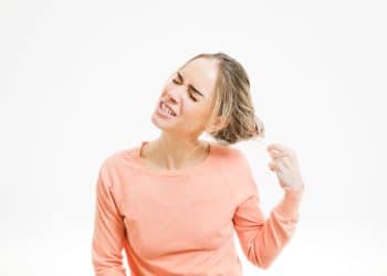 Mulher puxando seus próprios fios de cabelo.