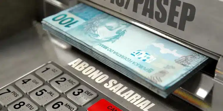 Caixa eletrônico liberando notas de R$ 100 com a inscrição PIS/Pasep e Abono Salarial em destaque, ilustrando o pagamento do benefício aos trabalhadores brasileiros