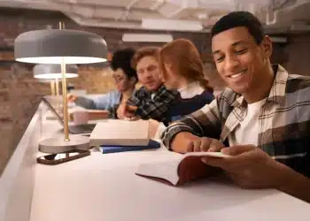 Estudantes concentrados em leitura e estudo em grupo representando o aulão solidário do Enem com preparação intensiva