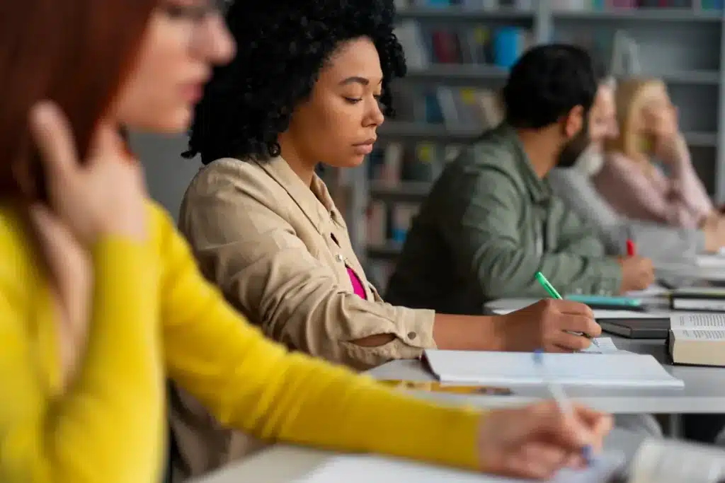 Estudantes fazendo anotações em sala durante preparação para o Enem, representando participação no Aulão Solidário