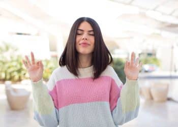 Mulher meditando e refletindo, simbolizando autossuficiência como chave para o sucesso e produtividade.