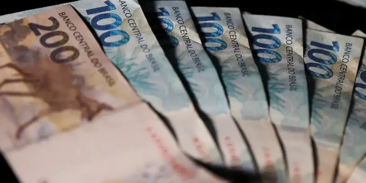 Notas de real brasileiro organizadas simbolizando pagamento do auxílio-creche de R$ 526,64 para novos beneficiários.