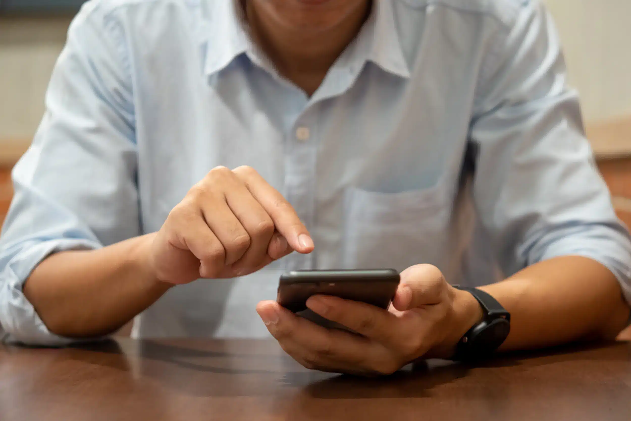 Pessoa consultando benefícios do governo pelo celular, usando canais oficiais.